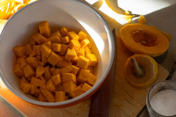 Bowl of diced squash next to cut pieces and salt
