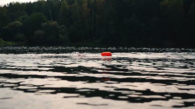 Swimmers in a lake in open water with with a safety buoy