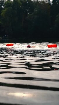 Swimmers in a lake in open water with with a safety buoy
