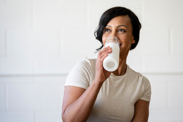 Smiling woman drinking water after a workout session