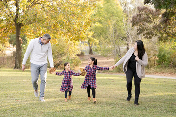 Obraz premium Family laughing and walking together on a sunny fall day