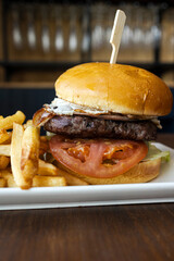 Gourmet burger with bacon, egg, and fries