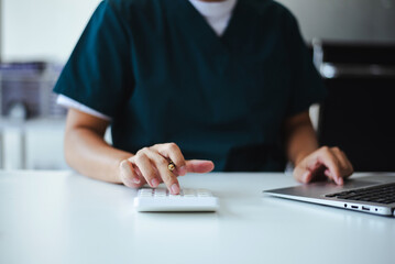 Professional healthcare worker calculating finance and budget data on a calculator. Medical accounting for cost analysis and insurance planning.
