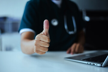 Professional doctor giving thumbs up sign for success and approval. Excellent medical service and quality healthcare work. Positive gesture concept.