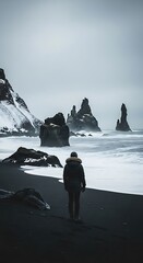 Solitary Figure on Reynisfjara Black Sand Beach in Winter.