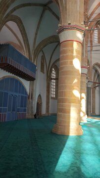 grand interior video of the Selimiye Mosque former St. Sophia Cathedral in Nicosia, showcasing its towering gothic columns, vaulted ceilings, and dramatic shafts of sunlight illuminating blue carpet