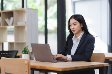 Asian businesswoman working on laptop in modern office