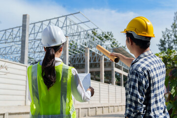 Engineers discussing building plans at active construction site