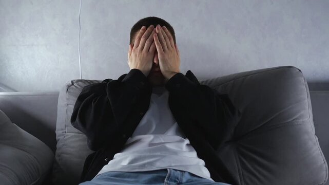 It's hot and stuffy in the room.
The man waves his arms at himself to cool off the heat.
High room temperature and poor ventilation