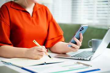 businesswoman hand writing on the notepad with new modern computer strategy diagram as concept