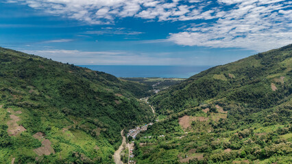 Aerial view of a small village along a coastal river and valley in Central Sulawesi, Indonesia.
