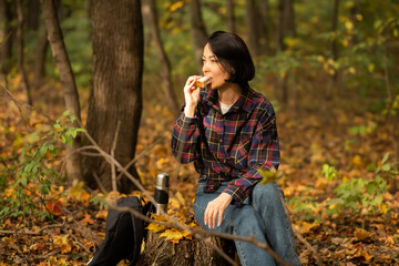 Woman with backpack hiking on footpath in autumn forest and relaxing outdoor.