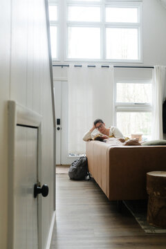 Woman reading a book in a cozy white modern cabin in winter