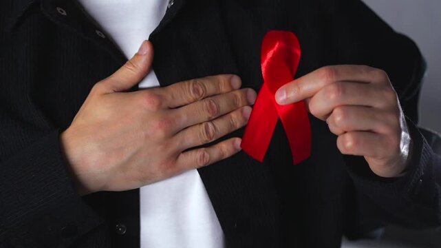 A red ribbon symbolizing solidarity with people living with HIV.
A symbol of HIV infection.
A red ribbon symbolizing support for people living with HIV.