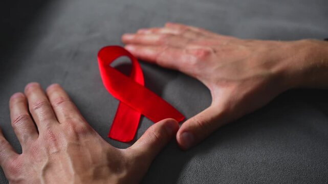 A red ribbon symbolizing solidarity with people living with HIV.
A symbol of HIV infection.
A red ribbon symbolizing support for people living with HIV.