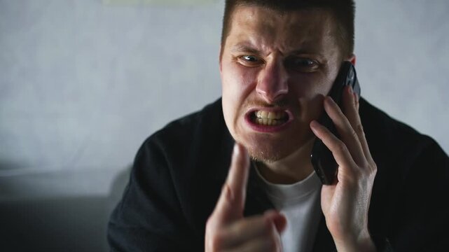 A man is yelling at his interlocutor on the phone and actively pestering him with something.
Telephone threats and conflict between people.
The man is yelling and getting very angry.