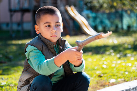 Young boy playing with stick in park