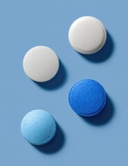 Four pills, light gray/white and light blue/teal,  arranged on a periwinkle-blue surface, casting subtle shadows