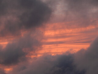 Photographie poétique de coucher de soleil aux tons pastel, avec des nuages légers et cotonneux baignant dans une lumière rose et dorée. Image apaisante idéale pour les projets liés à la nature.