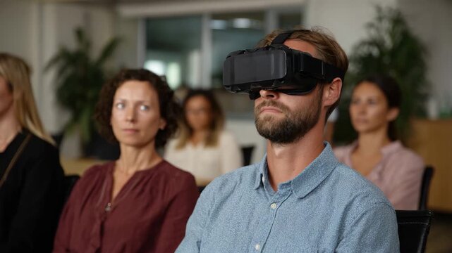 A participant is immersed in virtual reality while sitting amidst an audience, showcasing the blend of technology and social engagement in modern presentations.