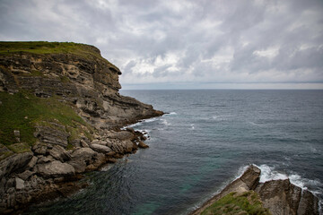 Scenic coastal cliff landscape overlooking the rough sea under cloudy skies perfect for nature and travel photography