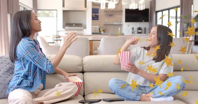 Sisters grabbing popcorn and tossing kernels for entertainment bonding with star confetti overlay