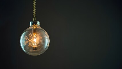 Christmas ornament with snowflake inside on dark background