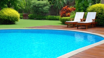 Relaxing poolside area with clear blue water and comfortable lounge chairs in a lush garden setting