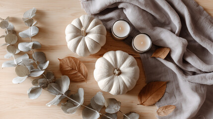 Composition automnale minimaliste avec citrouilles blanches, bougies et feuillages s&eacute;ch&eacute;s sur fond clair, style scandinave hygge