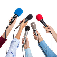 Microphones in the Spotlight: A collection of microphones held high, representing a press conference or media event, symbolizing the power of information and communication.