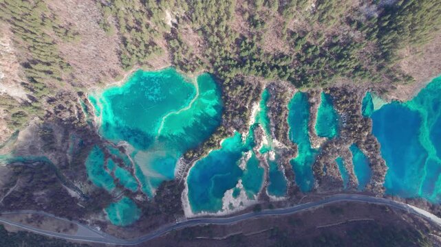 Drone view of Jiuzhaigou National Park in spring in Sichuan Province China. It features cascading waterfalls, turquoise blue lakes, and stunning mountain valleys. 4K fast motion footage travel concept