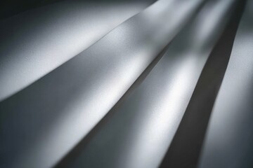 Abstract shot of white fabric folds, lit to highlight curves and textures, with deep shadows