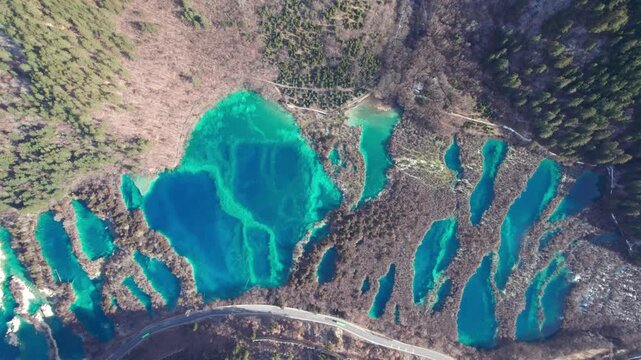 Drone view of Jiuzhaigou National Park in spring in Sichuan Province China. It features cascading waterfalls, turquoise blue lakes, and stunning mountain valleys. 4K fast motion footage travel concept