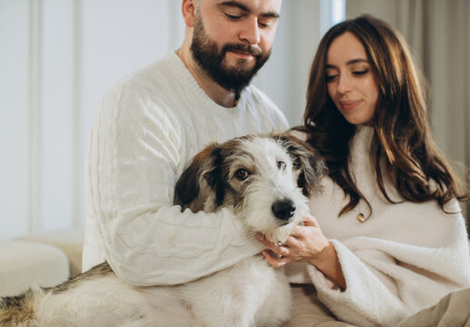 Couple enjoying cozy holiday moments with pet dog