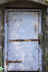 An old locked door painted in blue peeling paint, front view, background photo