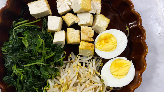 Indonesian food called "pecal". Pecal is an Indonesian dish comprises of vegetables which only contains bean sprouts, fried tofu, boiled eggs and spinach and usually served with peanut sauce