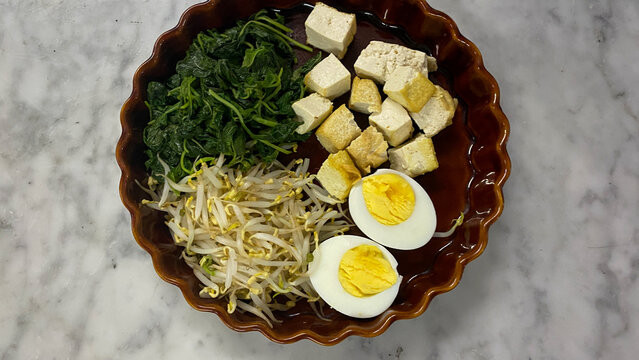 Indonesian food called "pecal". Pecal is an Indonesian dish comprises of vegetables which only contains bean sprouts, fried tofu, boiled eggs and spinach and usually served with peanut sauce