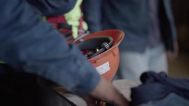 Slow motion close up of an orange safety helmet in an industrial workshop environment used for worker protection.