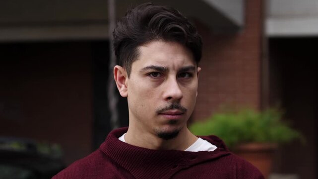 A young man with dark hair in a sweater shakes his head firmly to indicate refusal, showing disagreement and assertive indoor body language.