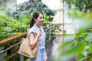 Woman visiting the green house garden full of plants