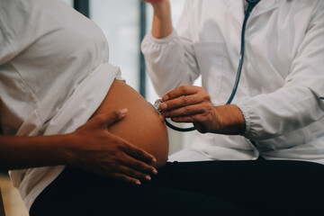 Female doctor is checking pregnant woman with stethoscope. Concept caring for pregnant woman