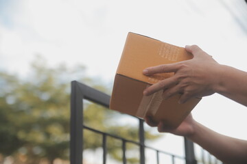 Asian delivery express courier young man use giving boxes to woman customer he wearing protective face mask at front home