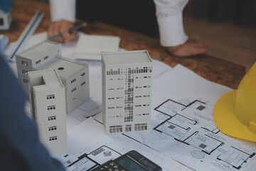 Construction and structure concept of Engineer or architect meeting for project working with partner and engineering tools on model building and blueprint in working site, contract for both companies.