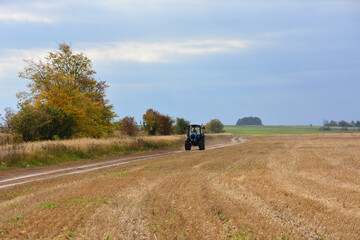 a Tractor on a dirt road in an autumn field