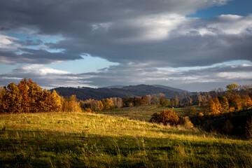 Fototapeta premium Sunset landscape with Sleza Mountain, Poland. Colorful autumnal foliage on the trees. 