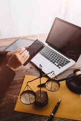 Justice and law concept.Male judge in a courtroom with the gavel, working with, computer and docking keyboard, eyeglasses, on table in morning light