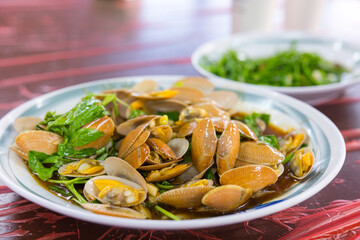 Stir fry clams being prepared in Taiwanese eatery