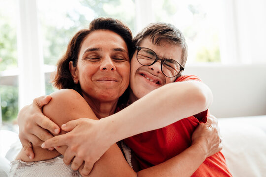 Mother and son with trisomy 21 embracing with joy and love