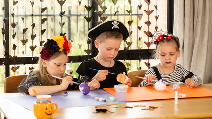 Kids making Halloween crafts in costume. Halloween craft workshop. 