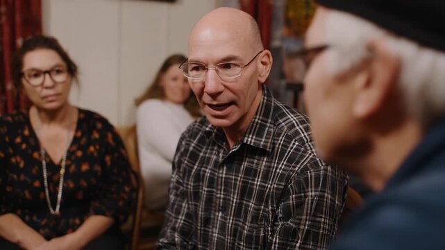An engaged group of individuals listens attentively to an elderly man sharing his story, showcasing the beauty of intergenerational communication and wisdom.
